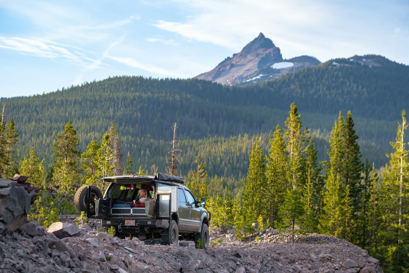 Black SUV on a dirt road near green trees during daytime